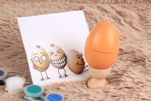 DIY hand-painted wooden egg toy set with colorful paints and a natural wood stand
