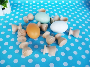 Close-up of wooden egg holders and realistic toy eggs on a blue polka dot background