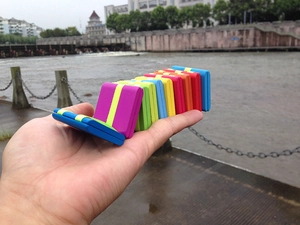 Close-up showing the dynamic folding motion of a colorful wooden Jacob's ladder toy
