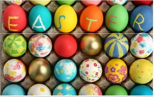 Close-up of colorful DIY hand-painted Easter eggs with patterns in a paper tray