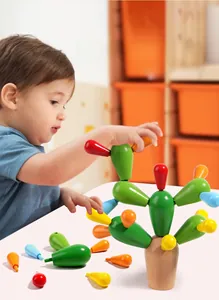 Toddler playing with wooden cactus building blocks to develop grip and motor skills