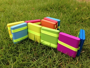 Classic wooden Jacob's ladder toy with colorful folding blocks on a green lawn