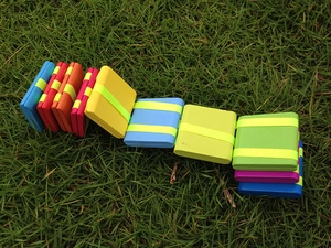 Detailed view of colorful wooden Jacob's Ladder toy blocks on a natural grass background