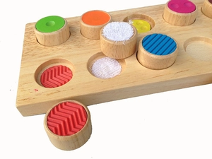 Detail of Montessori sensory wooden toy showing various tactile textures and colors