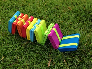 Detailed view of colorful wooden Jacob's ladder toy panels on green grass background