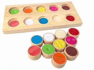 Macro view of wooden sensory board with colorful textured tactile matching cylinders