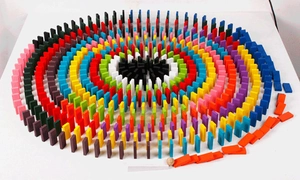 Top view of multicolored wooden domino blocks arranged in a radial circular pattern