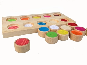 Detailed texture view of wooden sensory matching cylinders on a Montessori base