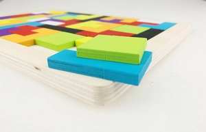 Primer plano de piezas de puzzle Tetris de madera colorida con bordes suaves en tablero
