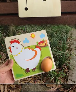 Macro shot of a wooden life cycle puzzle showing hen eggs being removed by hand