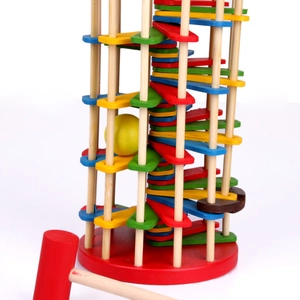 Close-up of wooden ball drop ladder toy with colorful spiral stairs and a red wooden hammer