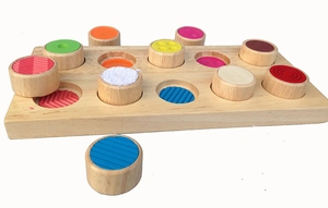 Top view of Montessori sensory toy with colorful wooden plugs and textured surfaces