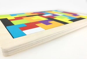 Primer plano de piezas de rompecabezas tetris de madera de colores en bandeja natural