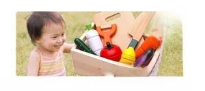 Detailed view of children's wooden vegetable set with magnetic toy knives and crate