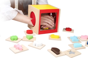 Vista macro di una scatola sensoriale in legno e blocchi geometrici colorati per bambini