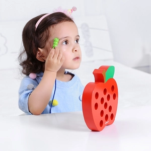 Detail of wooden apple lacing toy for toddlers showing hand-eye coordination training