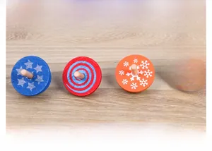 Lot de quatre toupies en bois colorées avec motifs d'étoiles, spirales et flocons