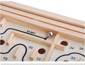 Close-up of wooden balance ball maze showing metal ball, path lines and start position