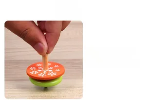 Vue détaillée d'une toupie en bois classique avec disque orange et motif de flocon de neige