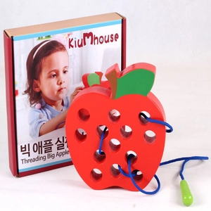 Detail of wooden apple threading toy with blue string and needle for kids' fine motor skills