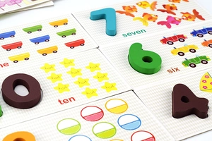 Close-up of wooden number puzzles with colorful figures and English word labels