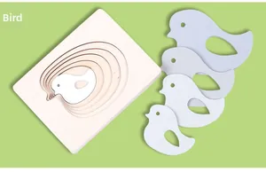 Detail view of multi-layered wooden bird puzzle pieces on a light green background
