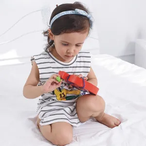 Toddler playing with wooden apple lacing toy on bed, improving motor skills