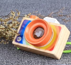 Close-up of wooden kaleidoscope camera toy with prism lens and rainbow design detail