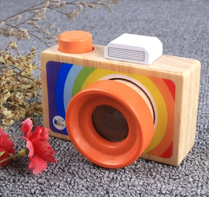 Detailed macro view of the wooden toy camera showing smooth wood grain and rainbow sticker