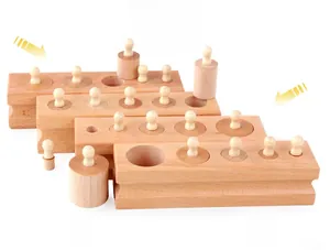 Detail view of four beech wood Montessori cylinder blocks with handles on white background