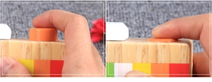 Detail showing the functional orange shutter button on a wooden toy camera