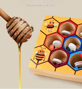 Detail of Montessori wooden beehive toy with colorful bees and a wooden honey dipper