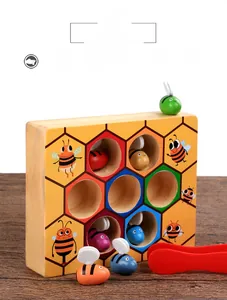 Close-up of wooden beehive game with colorful bees and tweezers for fine motor skills