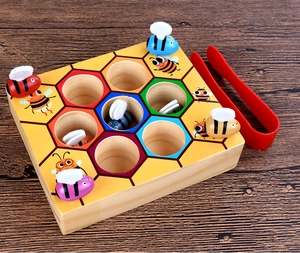 Close-up of wooden Montessori beehive game with colorful bees and red tweezers