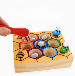 Macro detail of toddler using plastic tweezers to pick colorful bees from a wooden beehive