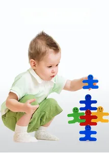 Focus view of a child playing with colorful smiling human-shaped balancing blocks