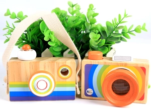 Detail view of two wooden toy cameras with rainbow patterns and colorful lenses