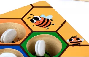 Detail of wooden honeybee puzzle game showing textured wings and hexagon sorting grid