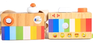 Close-up of wooden toy cameras with rainbow stripes and colorful emoji patterns