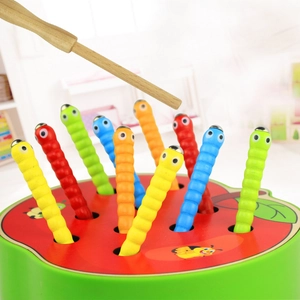 Close-up of wooden magnetic apple base and colorful worms toy for hand-eye coordination