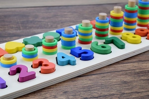 Close-up of wooden Montessori puzzle board with colorful numbers and counting rings