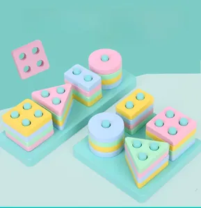 Vue de dessus de blocs géométriques pastels sur un support éducatif en bois massif