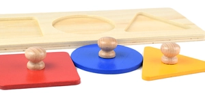 Macro shot of 3D geometric wooden puzzle with easy-grip knobs for toddlers