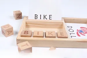 Macro view of wooden letter blocks and educational word cards in a timber tray