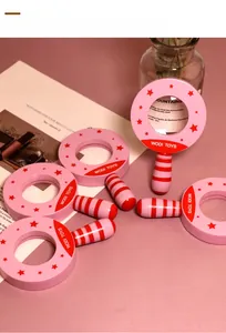 Flat lay of pink wooden magnifying glasses with star patterns for children's science play