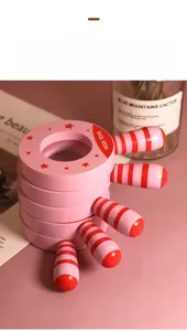 Detailed view of pink wooden steering wheel toy with red star and striped handle grip