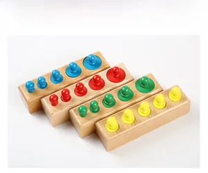 Gros plan de quatre blocs de cylindres Montessori colorés en hêtre pour l'éveil des enfants