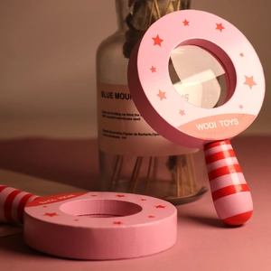 Pink wooden magnifying glass toy with star patterns and striped handle for kids