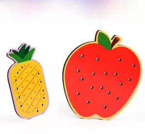 Détail de planches à lacer en bois en forme de pomme et d'ananas pour enfants