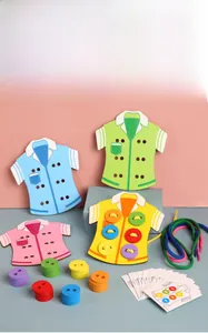 Close-up of wooden sewing toy with colorful shirts, buttons and threads for motor skills